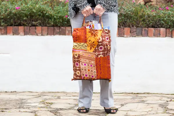 Frau trägt Lebensmittel in Mehrwegtasche — Stockfoto