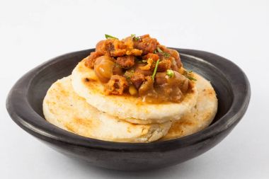 Kolombiyalı arepa fasulye ve domuz eti kabuğu ile tepesinde