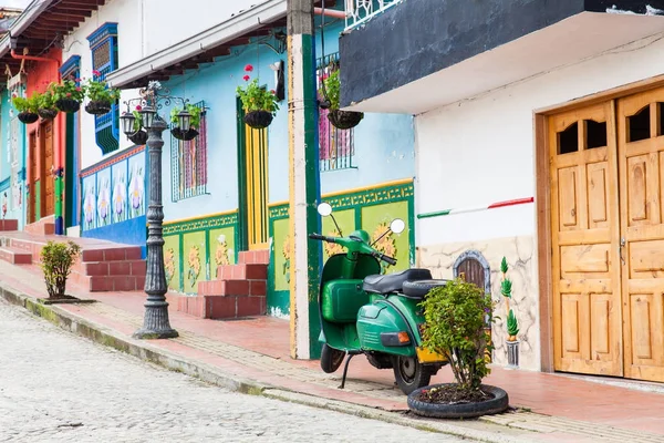 Zelená motocyklu na barevné město Guatape, Antioquia. — Stock fotografie