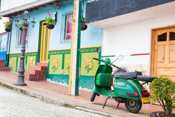 Zelená motocyklu na barevné město Guatape, Antioquia. — Stock fotografie