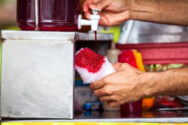 Kolombiya 'nın Cali şehrinde bir sokak satıcısı. Çikolata adı verilen geleneksel tatlı su buzunu hazırlayıp satıyor.