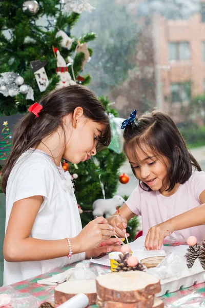 Duas irmãzinhas se divertindo ao fazer artesanato Natal Natividade com em casa - Família real — Fotografia de Stock