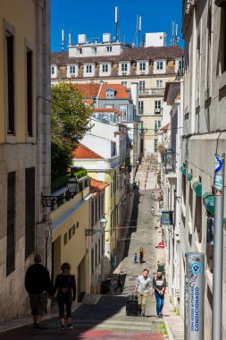 Lizbon şehir merkezindeki güzel, sarp sokaklarda yürüyen insanlar.