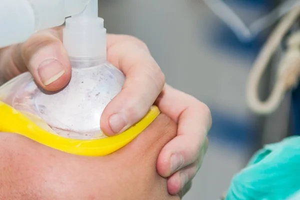 Primer plano de un anestesista en un quirófano sosteniendo una máscara de oxígeno en la cara del paciente —  Fotos de Stock