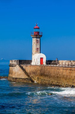 1886 'da inşa edilen ve Porto şehrindeki Douro Nehri ağzında bulunan tarihi Felgueiras Deniz Feneri' nde güzel bir bahar gününün tadını çıkaran balıkçı.