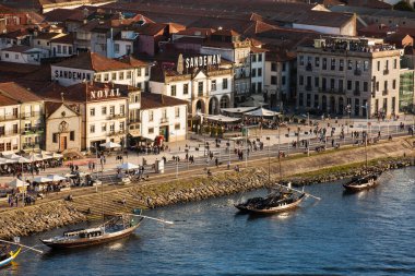 Vila Nova de Gaia manzarası, geleneksel tekneler ve Douro Nehri güzel bir bahar günbatımında