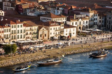Vila Nova de Gaia manzarası, geleneksel tekneler ve Douro Nehri güzel bir bahar günbatımında