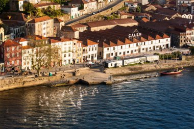 Vila Nova de Gaia manzarası, geleneksel tekneler ve Douro Nehri güzel bir bahar günbatımında