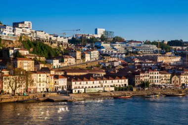 Vila Nova de Gaia manzarası, geleneksel tekneler ve Douro Nehri güzel bir bahar günbatımında