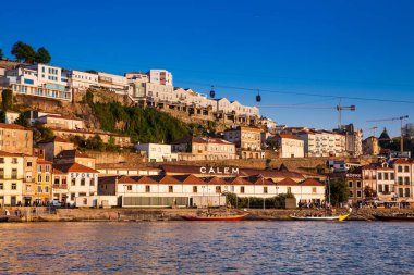 Vila Nova de Gaia manzarası, geleneksel tekneler ve Douro Nehri güzel bir bahar günbatımında