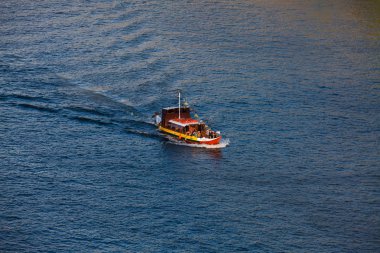 Portekiz 'in Porto şehrinde güzel bir bahar gününde Duoro Nehri' nde klasik bir teknede turistler. 