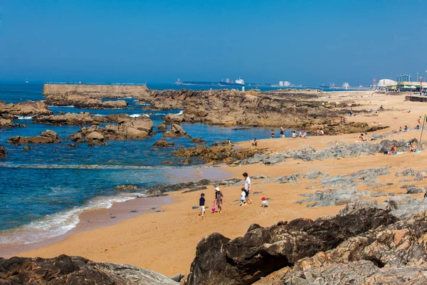 Les gens profitent d'une journée ensoleillée au début du printemps sur les belles plages le long de la côte de Porto — Photo