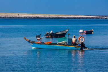 Porto şehrinde güzel bir bahar gününde Douro Nehri ağzında yelken açan bir adam. 