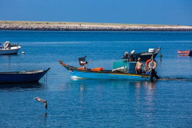 Porto şehrinde güzel bir bahar gününde Douro Nehri ağzında yelken açan bir adam. 