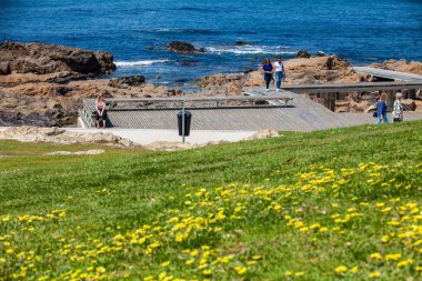 İnsanlar Porto şehri kıyı şeridi boyunca gezinti alanında güzel bir bahar gününün tadını çıkarıyorlar.