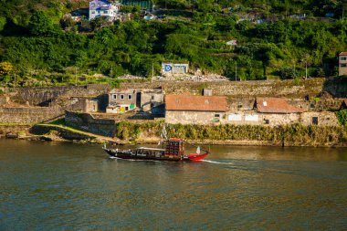 Turistler geleneksel bir teknede Douro Nehri 'nde yelken açıyorlar.