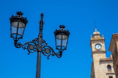 Güzel bir sokak lambası ve Salamanca şehir merkezinde Zamora Caddesi 'ndeki antik bir binanın saat kulesi.