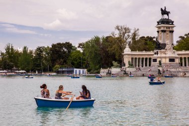 MADRID, SPAIN - MAY, 2018: Tourists and locals enjoying a beautiful spring day sailing at the Retiro Park pond