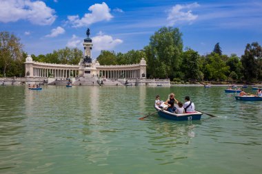 MADRID, SPAIN - MAY, 2018: Tourists and locals enjoying a beautiful spring day sailing at the Retiro Park pond
