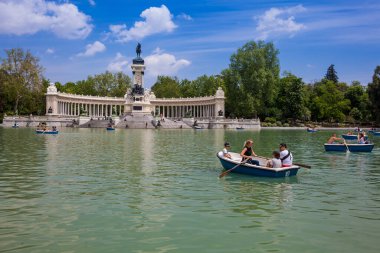 MADRID, SPAIN - MAY, 2018: Tourists and locals enjoying a beautiful spring day sailing at the Retiro Park pond