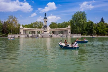 MADRID, SPAIN - MAY, 2018: Tourists and locals enjoying a beautiful spring day sailing at the Retiro Park pond