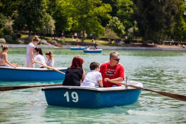 MADRID, SPAIN - MAY, 2018: Tourists and locals enjoying a beautiful spring day sailing at the Retiro Park pond