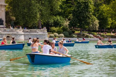MADRID, SPAIN - MAY, 2018: Tourists and locals enjoying a beautiful spring day sailing at the Retiro Park pond