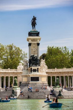 MADRID, SPAIN - MAY, 2018: Tourists and locals enjoying a beautiful spring day sailing at the Retiro Park pond