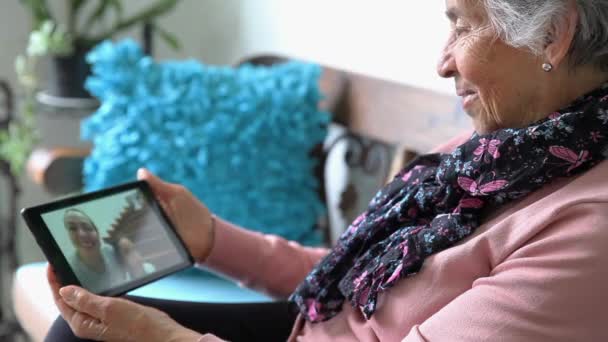 Senior vrouw alleen thuis video chatten met haar familie — Stockvideo