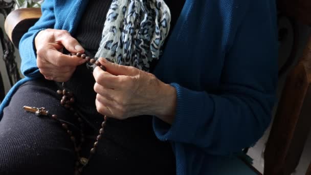 Senioren vrouw alleen thuis bidden de Heilige Rozenkrans — Stockvideo