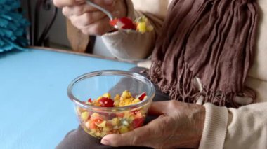 Evde meyve yiyen yaşlı bir kadın. Sağlıklı beslenme ya da sağlıklı yaşam tarzı kavramı