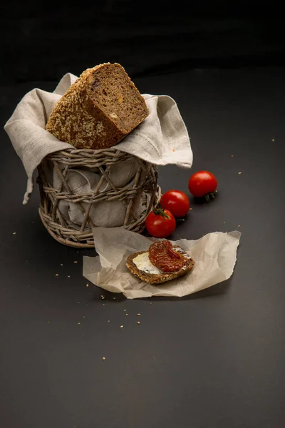 Piece of black bread with butter and sun dried tomato — Stock Photo, Image