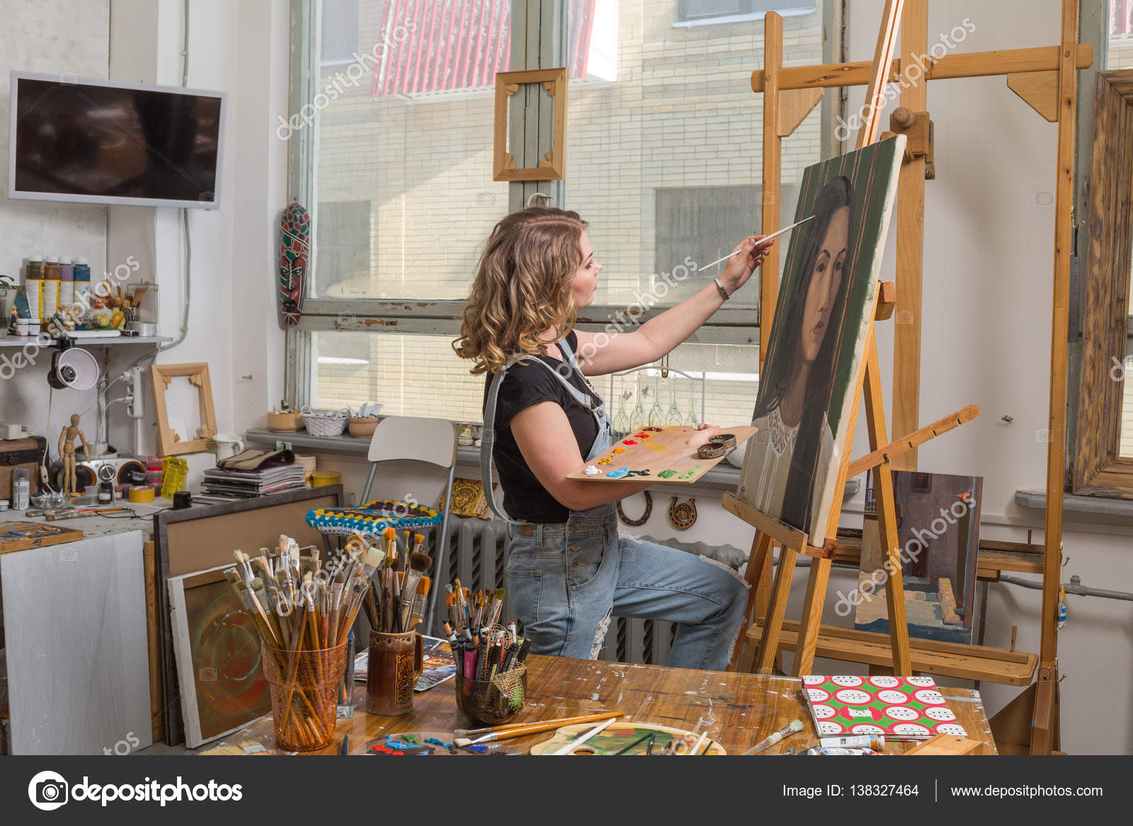 Junger Künstler in seinem Atelier beim Malen eines Bildes Stockfotografie lizenzfreie Fotos