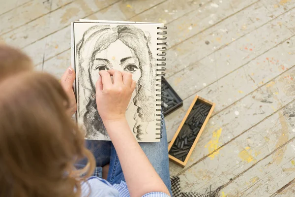 Young girl doing a sketch of natural charcoal on paper — Stock Photo, Image