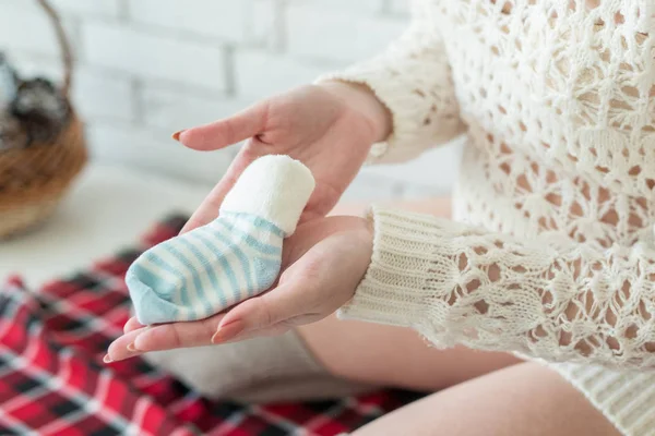 Hermosa chica embarazada muestra pequeña bota de su bebé — Foto de Stock