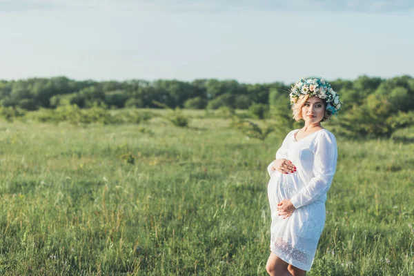 Jeune fille enceinte dans une robe blanche sur la nature — Photo