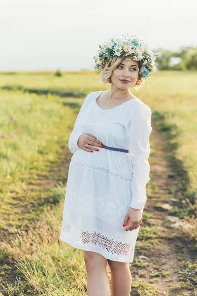 Jong zwanger meisje in een witte jurk over de aard — Stockfoto