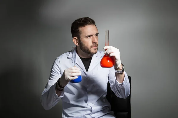 Scientifique compare le liquide dans le laboratoire — Photo