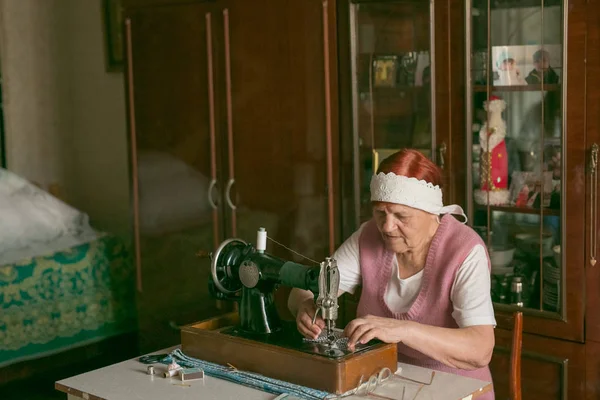 Starsza Biała Kobieta Pomarszczonymi Rękami Twarzą Pracuje Maszynie Szycia Domu — Zdjęcie stockowe