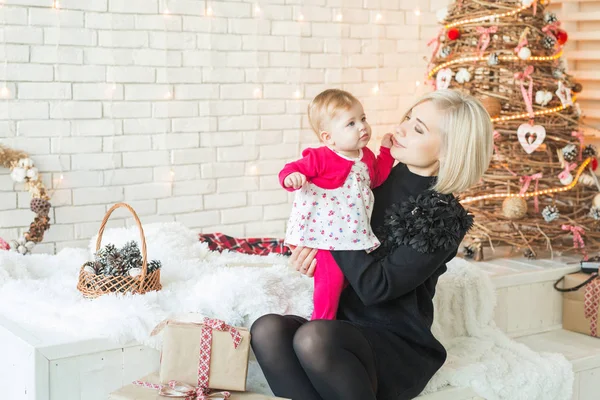 Beautiful blonde girl with her daughter on Christmas