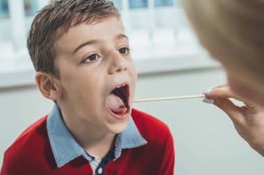 Doktor covid-19 virüsünü tespit etmek için çocuktan bir test alır.