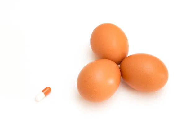 卵と白い背景で隔離の丸薬 — ストック写真