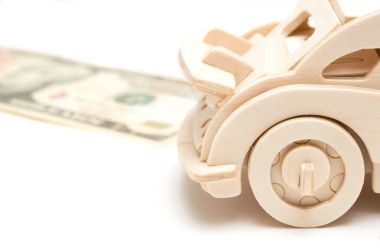 ahşap araba ve ABD Doları Beyaz arka plan üzerinde izole. Satın alma, Kiralama, sigorta, yakıt, servis ve onarım masrafları için kavramı.