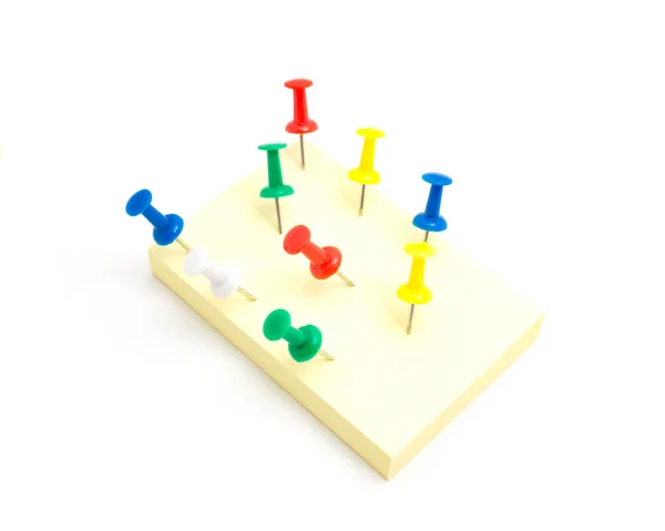 Nine push pins and yellow sticky note on isolated white background — Stock Photo, Image