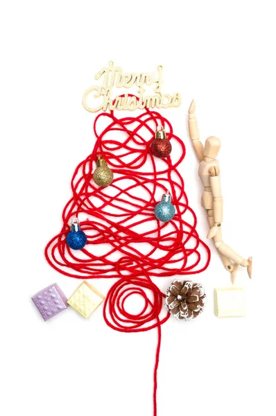 Un árbol hecho de hilo rojo y feliz texto de Navidad, bola, caja pequeña, cono de pino, muñeca conjunta sobre fondo blanco — Foto de Stock