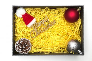 Neşeli Noel metin ve kürk şapka, topu, çam kozalağı siyah hediye kutusunda sarı ambalaj malzemesi ile