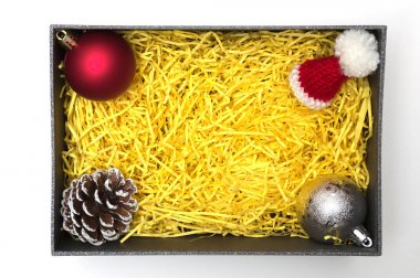 Top ve çam koni, kürk şapka siyah hediye kutusunda sarı ambalaj malzemesi ile