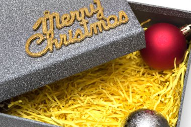 Neşeli Noel metin ve topu siyah hediye kutusunda sarı ambalaj malzemesi ile