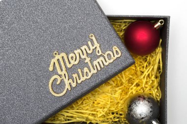 Neşeli Noel metin ve topu siyah hediye kutusunda sarı ambalaj malzemesi ile