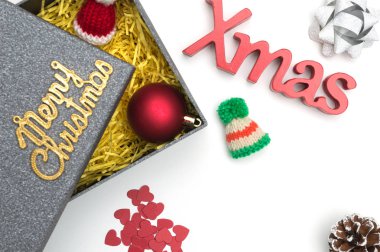 Merry christmas ve X-mas metin, kürk şapka, top, şerit, çam kozalağı, siyah hediye kutusunda sarı ambalaj malzemesi ile kalp